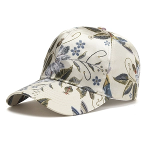 Close-up of floral embroidery on a beige satin baseball cap with detailed stitching