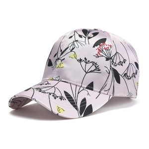 Detail view of pink satin baseball cap with floral print and silk-like finish