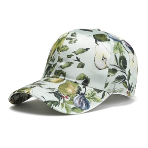 Detailed macro view of satin baseball cap featuring vibrant fruit and botanical leaf prints