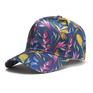 Detail of dark blue baseball cap featuring tropical floral and butterfly prints