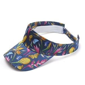 Detail view of tropical floral print sun visor with colorful butterflies and botanical patterns