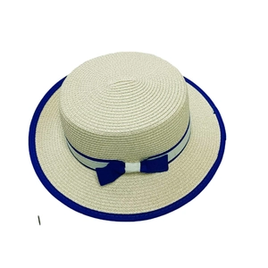 Flacher beige Strohhut mit blauer Schleife und Band für den Sommerurlaub am Strand