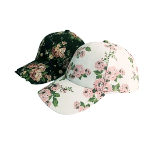 Detailansicht von Blumen-Baseballkappen in Schwarz und Beige mit Rosenmuster und Baumwolle
