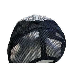 Détail d'une casquette en maille noire ornée de perles blanches et de strass scintillants