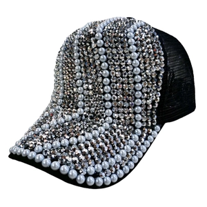Détails de perles bleues et strass argentés sertis sur une casquette en maille noire