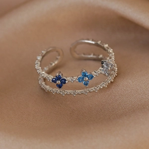 Macro detail of silver geometric double-layer ring with micro-set blue zircon flowers