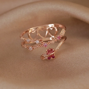Close-up of rose gold double-layered heart ring with pink zircon on silk background