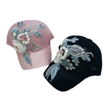 Detailed view of floral embroidery and pearl accents on hollow lace baseball caps