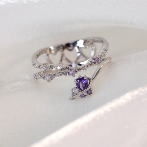 Macro shot of silver ring with purple heart-shaped stone and hollow heart pattern