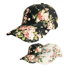 Close-up of floral hollow baseball caps in black and cream with rose pattern