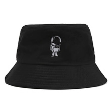 Close-up of a black bucket hat featuring a white embroidered astronaut on the front
