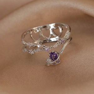 Close-up of silver crown ring featuring a purple heart-shaped stone and pink zircons
