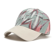 Detail of floral embroidery on crown with beige brim of breathable baseball cap