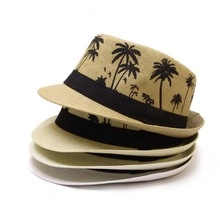 Détail de chapeaux de paille avec imprimé palmier tropical et ruban noir élégant