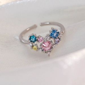 Macro shot of colorful zircon heart ring with adjustable silver-tone open band