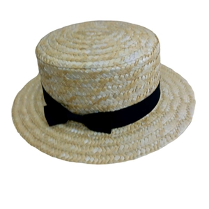 Vue détaillée de la texture en paille de blé et du ruban noir sur le chapeau canotier