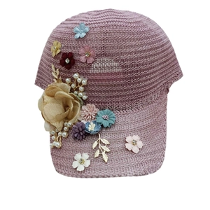 Detail of dusty pink crochet baseball cap with floral embroidery and bead accents
