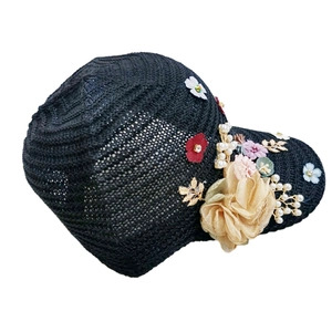 Detail of black crochet baseball cap with 3D fabric flowers, pearls and golden leaves