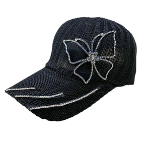 Detailed view of black baseball cap with sparkling rhinestone butterfly design on side