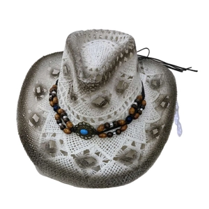 Détail d'un chapeau de cowboy au crochet blanc avec perles turquoise et tissage