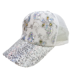 Detailed shot of white lace baseball cap featuring floral embroidery and silver sequins