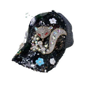 Close-up of black sequin baseball cap featuring rhinestone fox and 3D floral details