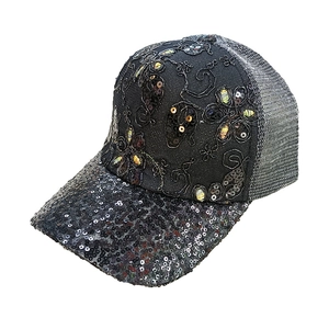 Close-up of black mesh trucker hat featuring sequins and floral embroidery details