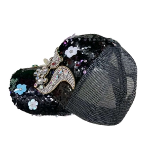 Detail of black sequined baseball cap featuring breathable mesh and rhinestone dolphin decor
