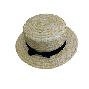Détail du tissage en paille et du ruban noir avec nœud sur un chapeau canotier