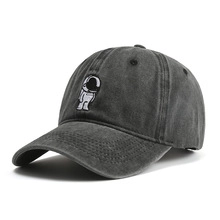 Detail of washed grey baseball cap featuring a small astronaut embroidery on premium cotton