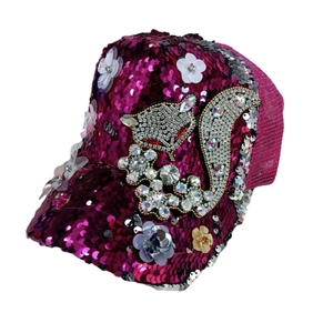 Detail of magenta sequin baseball cap featuring a rhinestone fox and floral accents