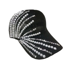 Detail of black knitted baseball cap with white pearls and silver rhinestones decoration