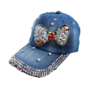 Macro detail of denim baseball cap with colorful rhinestone bow and crystal accents
