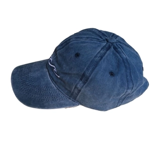 Close-up of side view on washed blue denim baseball cap with white wave embroidery