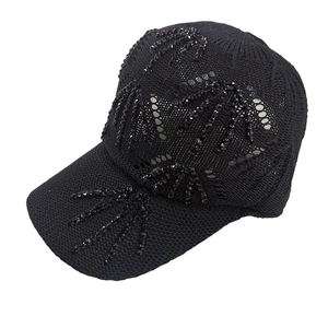 Detailed texture of black knit baseball cap featuring sequined palm tree pattern