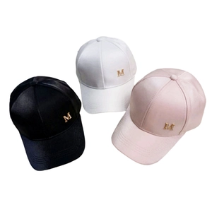 Detail of satin fabric texture and golden metal M letter on colorful baseball caps