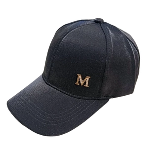Detail of black baseball cap with golden metal letter M and sparkling rhinestone embellishments