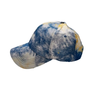Detail view of tie-dye baseball cap fabric texture in blue yellow and white tones