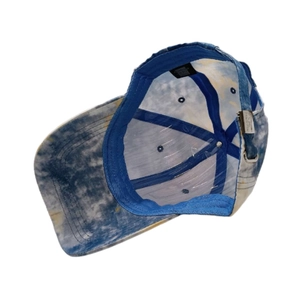 Detailed interior of blue tie-dye baseball cap showing sweatband and metal buckle
