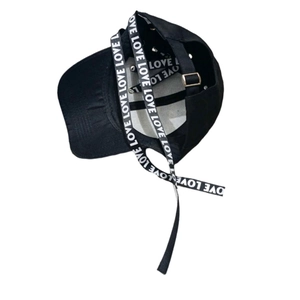 Casquette de baseball noire style urbain avec de longs rubans imprimés Love sur fond blanc