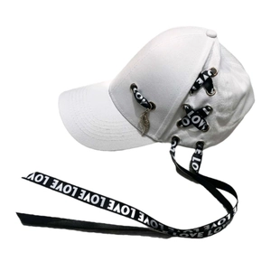 Détail de casquette de baseball blanche avec ruban noir et pendentif plume en métal