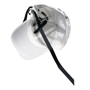 Détail d'une casquette blanche en coton avec de longs rubans noirs imprimés LOVE