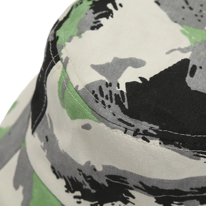 Gros plan sur les coutures fines et le motif camouflage d'un bob en toile