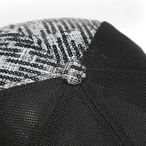Detailed close-up of glittering black sequins and breathable mesh fabric on a baseball cap