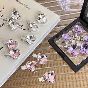 Sparkling heart rhinestone hair clips in pink and purple on elegant studio props