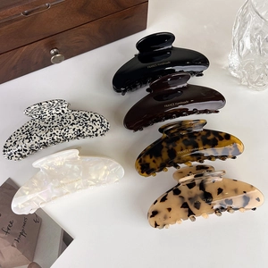Detailed view of six handmade acetate hair claws in various elegant patterns and colors