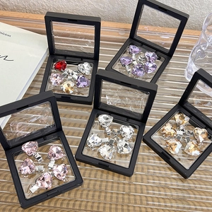 Macro shot of colorful rhinestone heart hairpins displayed in black PE film gift boxes