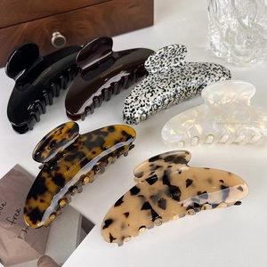 Handmade acetate hair claws in various patterns like tortoiseshell and pearl white finish