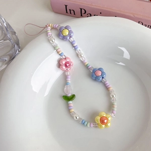 Vue détaillée de la dragonne de téléphone en perles tulipes dans un bol en céramique