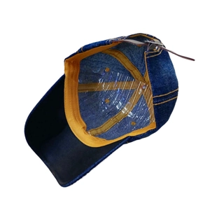 Detail view of denim baseball cap interior with yellow sweatband and adjustable back strap